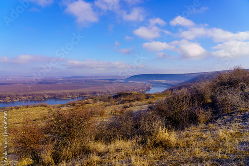 Beautiful view of the hilly valley with the river soothing winter nature. Background with copy space