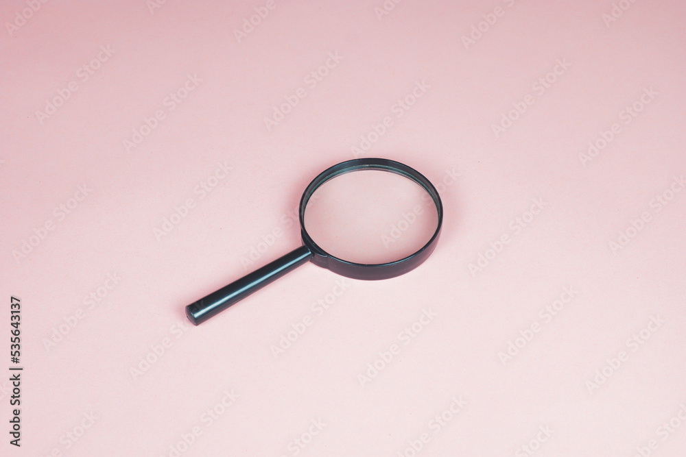 Magnifying glass on the pink background. Magnifier top view. Loupe as a concept of focusing and zooming. Copy space for text. Magnifying glass on the pink background. Magnifier top view. Loupe as a concept of focusing and zooming. Copy space for text.