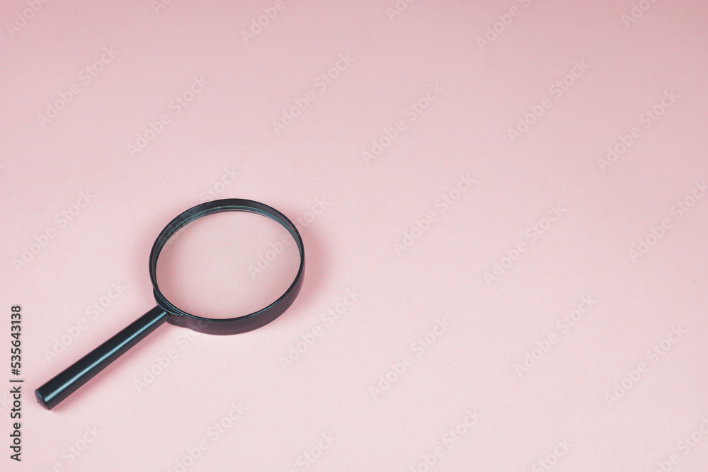 Magnifying glass on the pink background. Magnifier top view. Loupe as a concept of focusing and zooming. Copy space for text. Magnifying glass on the pink background. Magnifier top view. Loupe as a concept of focusing and zooming. Copy space for text.