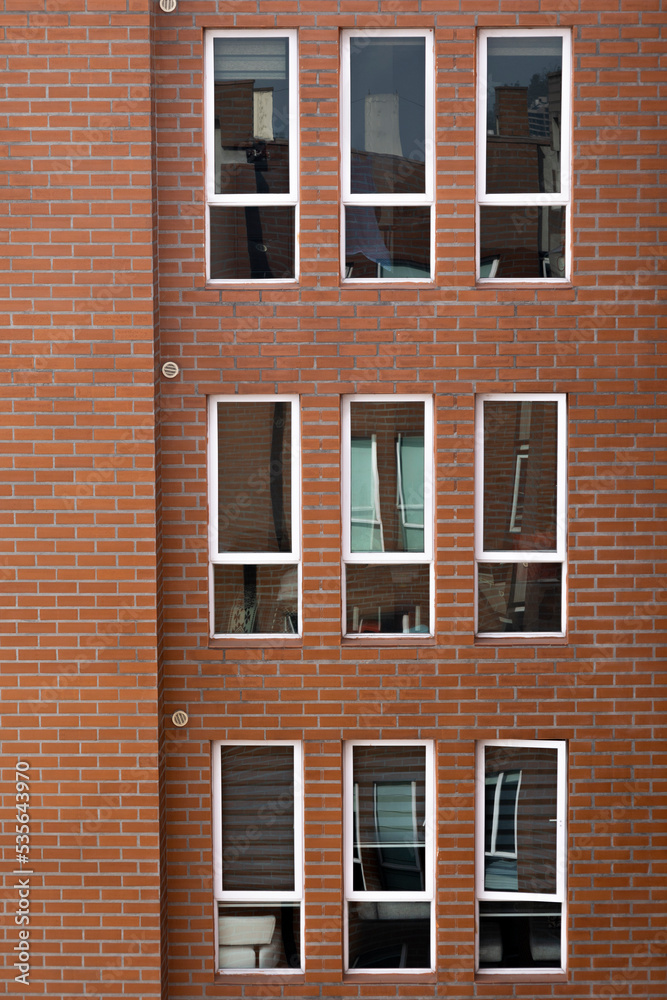 residential apartment with windows and brick wall, background with details of architecture decoration, texture and geometric figures on the facade