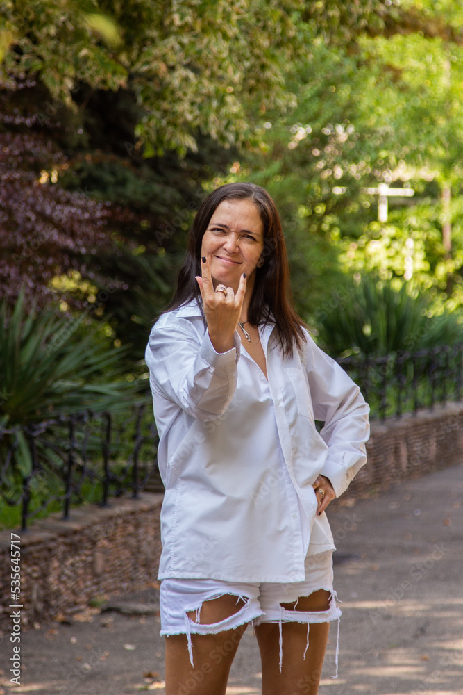 beautiful brunette woman in a white shirt walks in the park beautiful brunette woman in a white shirt walks in the park