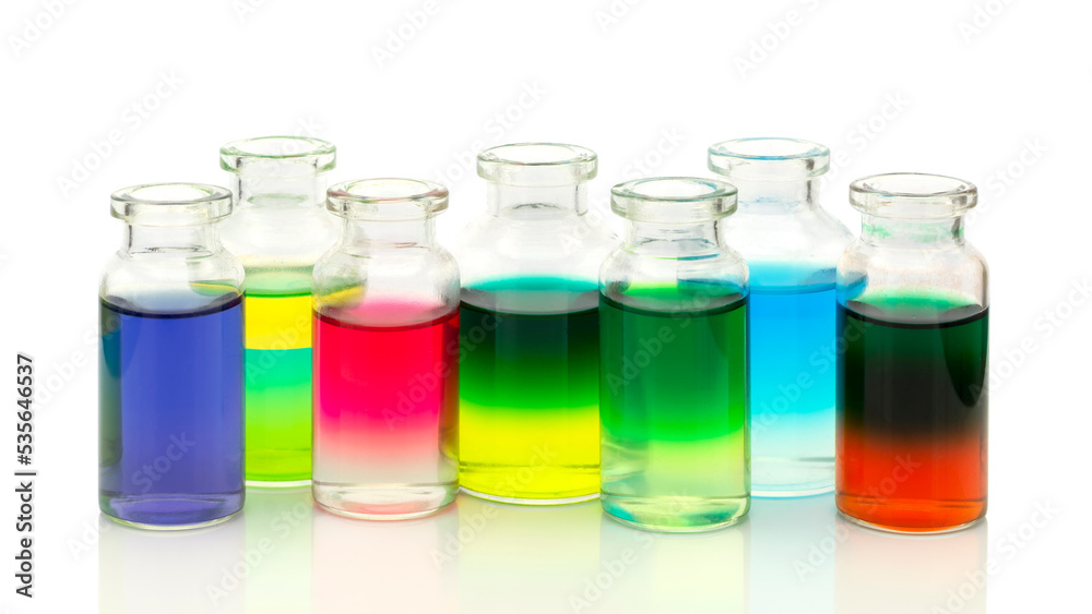 Colored water layers in small glass bottles isolated on white background Colored water layers in small glass bottles isolated on white background