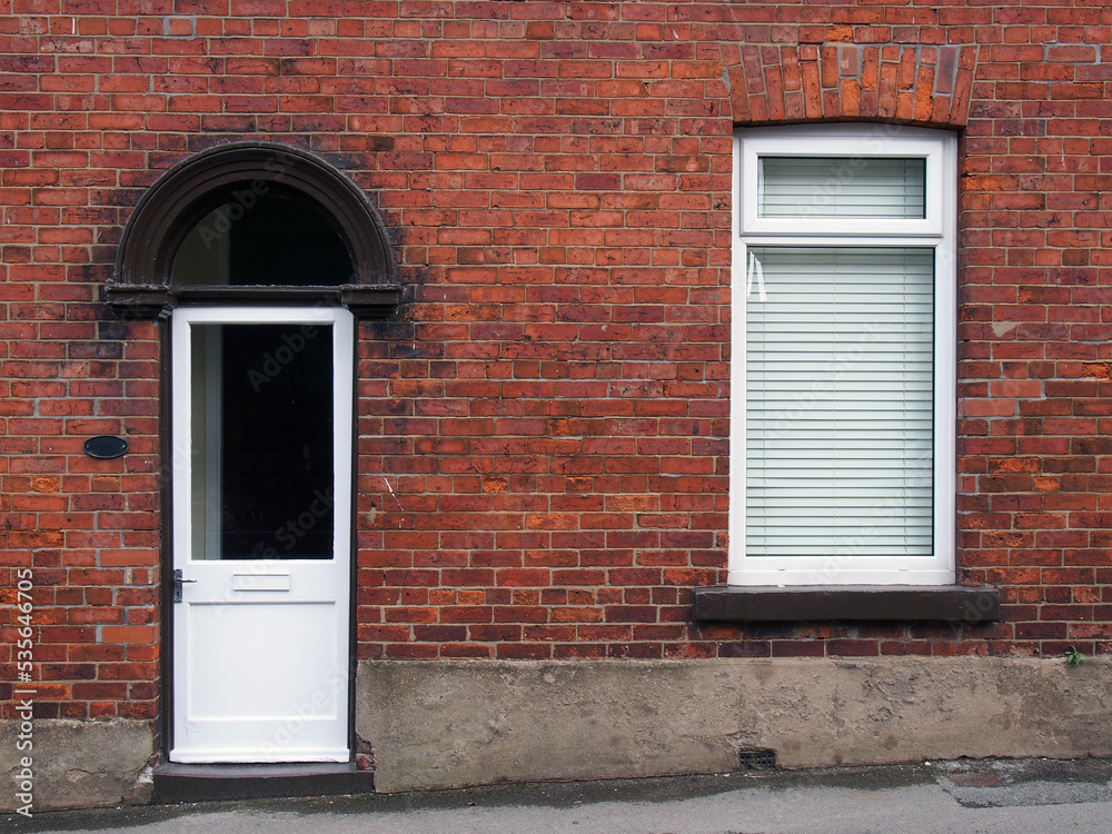 white front door and window of a typical old brick british terraced