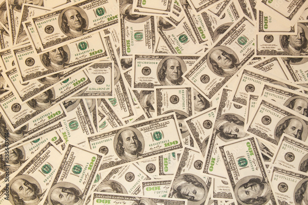 Many hundred dollar bills on the table. One hundred US dollar bills background. U.S. dollars. Banking and finance signs. Much money background. Top view. Close-up Many hundred dollar bills on the table. One hundred US dollar bills background. U.S. dollars. Banking and finance signs. Much money background. Top view. Close-up
