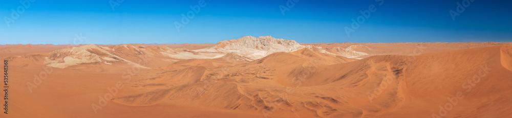panorama of mountain in between dunes with blue sky at sossuvlei national park in Namibia, stunning wallpaper