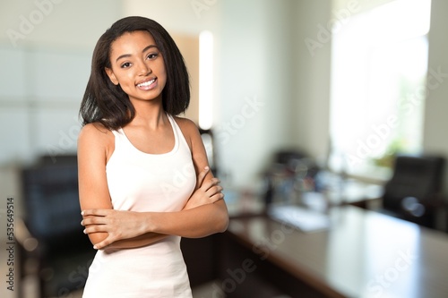 Happy young woman posing in office room indoors