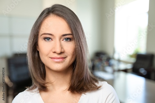 Happy young woman posing in office room indoors