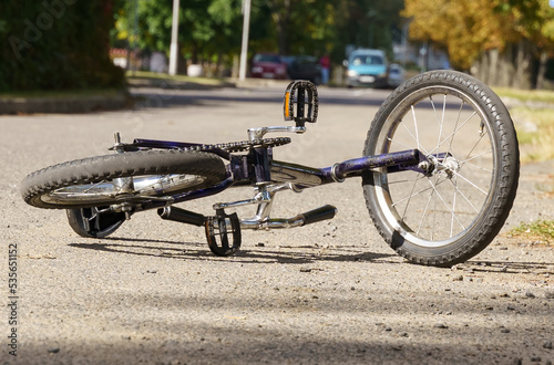 A bicycle lies on the road after a car hit a cyclist.