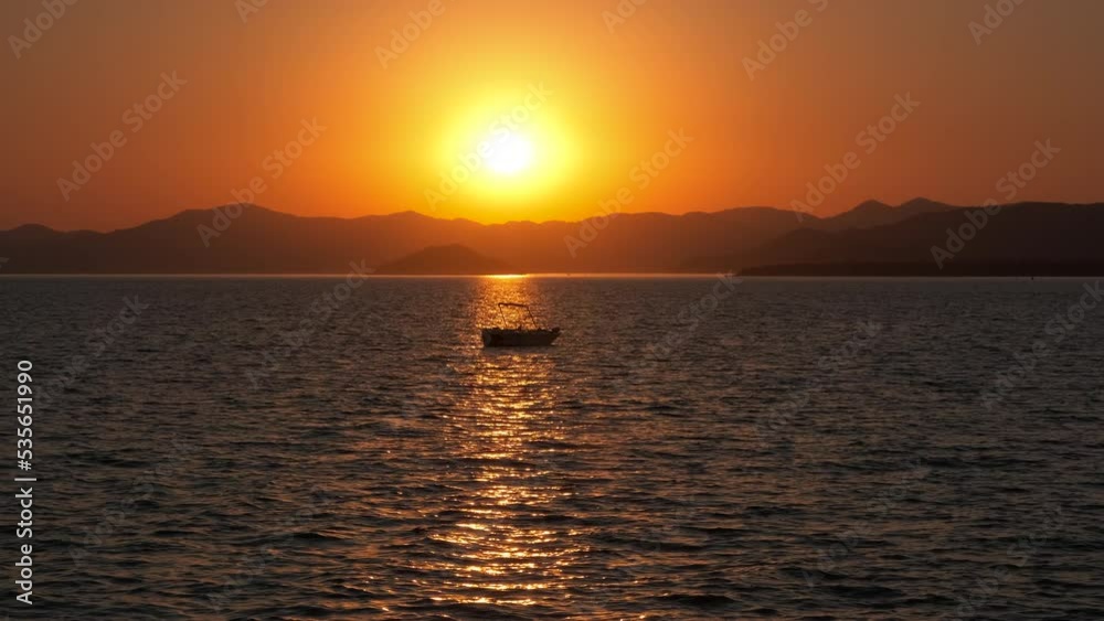 Afterglow sunset by yacht sihlouette. A view of moving away silhouette of nice boat in the sea water against red sky in sunset. Afterglow sunset by yacht sihlouette. A view of moving away silhouette of nice boat in the sea water against red sky in sunset.