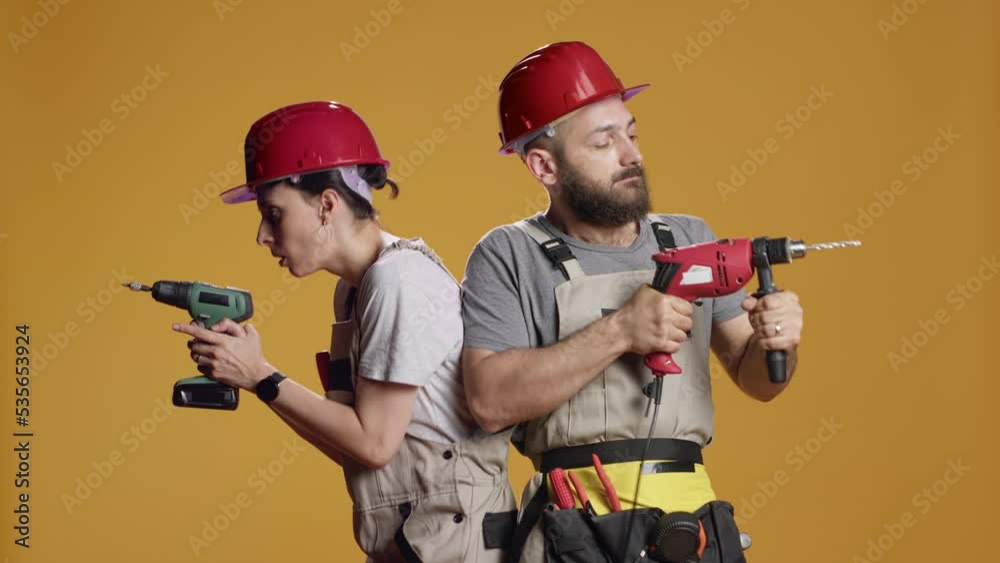 Construction workers using power drill gun to work on industrial