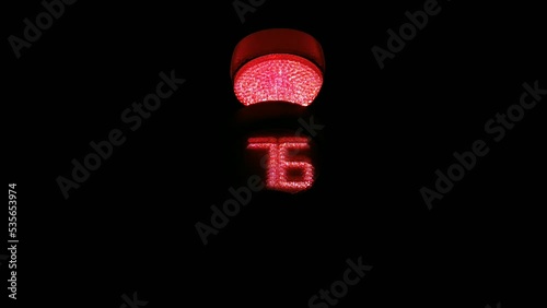 traffic light at night shows red light and counting seconds. road stop warning color photo