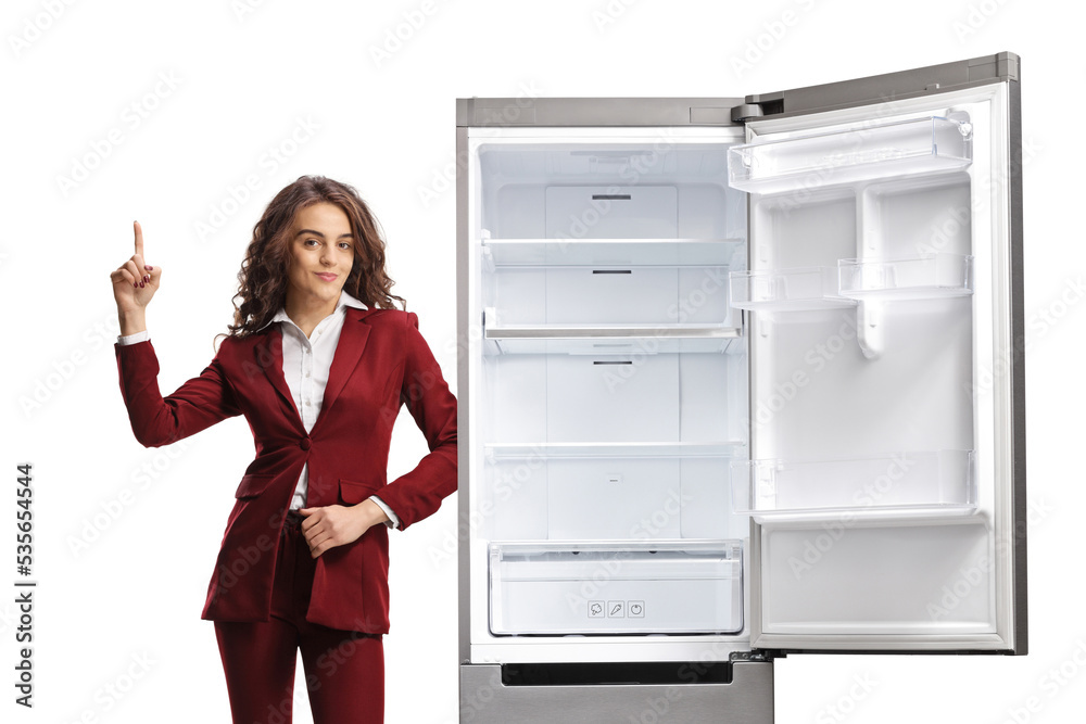 Professional woman pointing up and leaning on a fridge Professional woman pointing up and leaning on a fridge