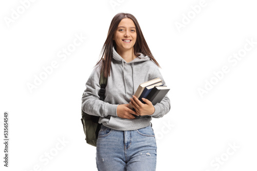 Female student carrying books and walking towards camera