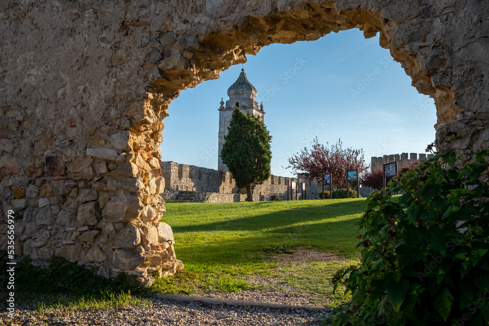 View of part of the castle wall of Montemor-o-Velho. Interior framing of broken stone wall, we can see the wall and the bell tower.