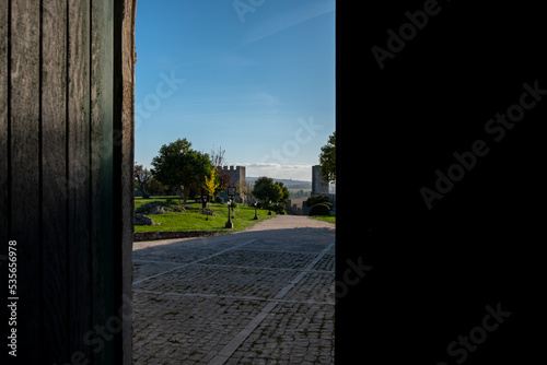 View of stone walk path and garden of the castle of Montemor-o-Velho from the chapel half open door. Montemor-o-Velho  Coimbra  Portugal