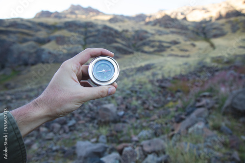Man holding a compass on a mountain background