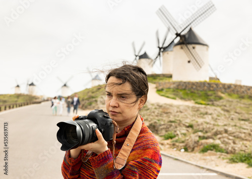 Tourist with camera in front of the windmills in the Spanish city of Consuegra