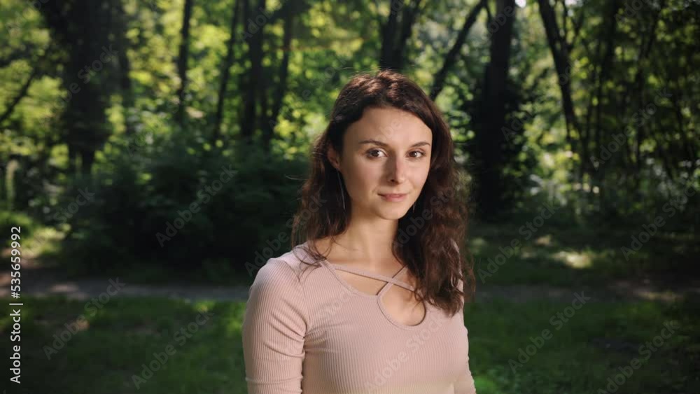 During sunset, a woman smiles to camera while looking at the sunset, smiling girl looks toward the camera while laughing. During sunset, a woman smiles to camera while looking at the sunset, smiling girl looks toward the camera while laughing.