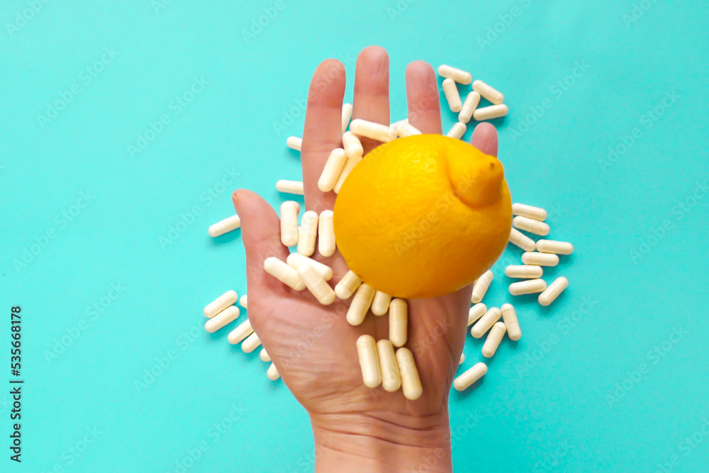Taking vitamin C tablets.White capsules of vitamin C in a hand and