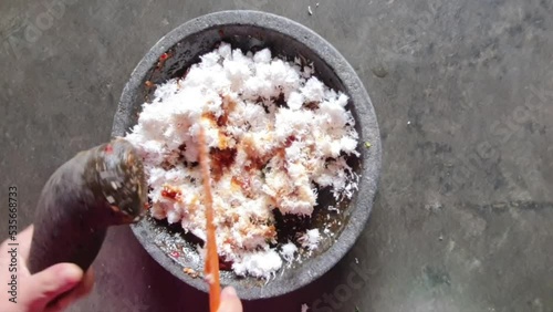 The process of making urap seasoning. Made from grated coconut mixed with chili sauce and onions photo