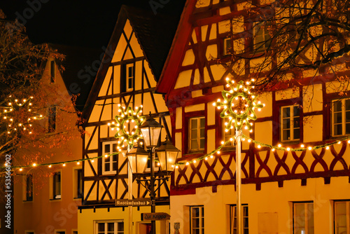 Christmas time in Europe.festive illumination in Germany.half timbered houses and glowing decorations.Shining garlands of European Christmas streets.Dark background with shimmering golden garlands.