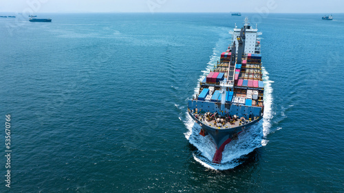 Aerial front of cargo ship carrying container and running