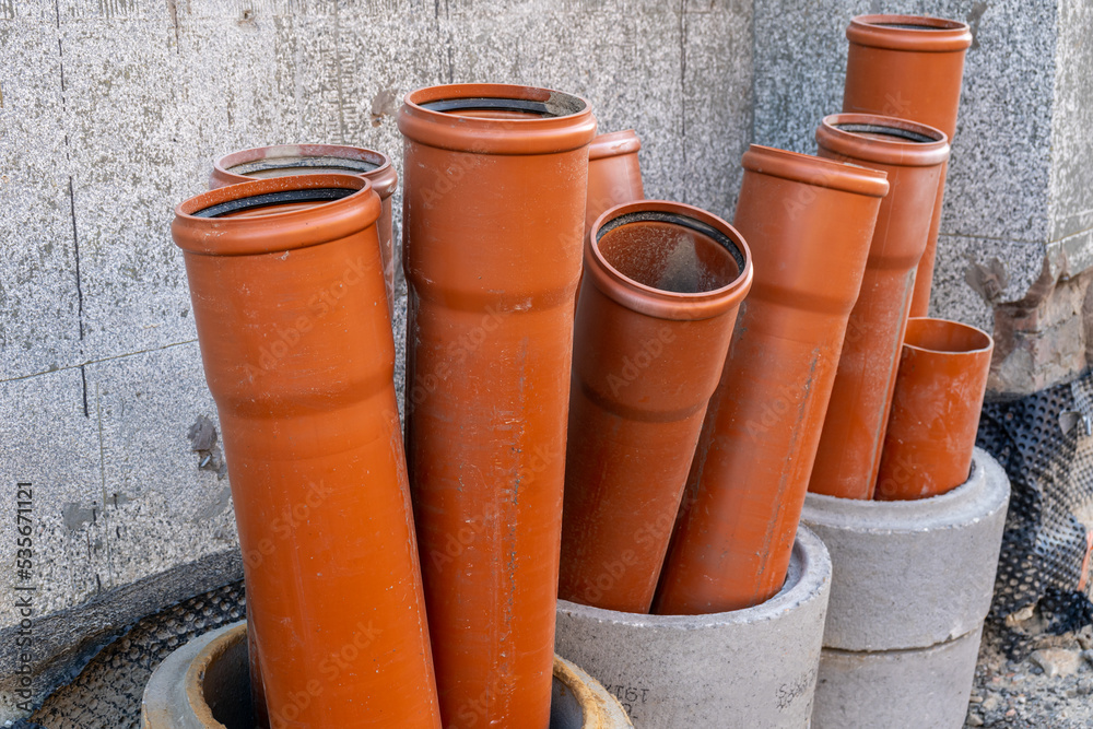Stack of brown pvc pipes. Close up of orange plastic pipes on construction. Industrial background Stack of brown pvc pipes. Close up of orange plastic pipes on construction. Industrial background