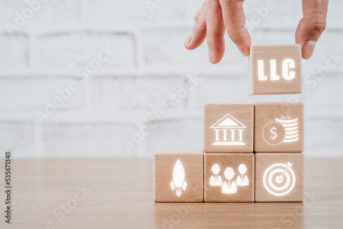 Photography Limited Liability Company (LLC) Business Concept, Person hand holding wooden block with limited liability company icon on Vr screen
