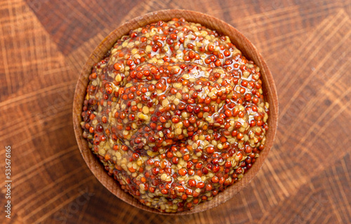 A Bowl of Whole Grain Mustard on a Wooden Butcher Block photo