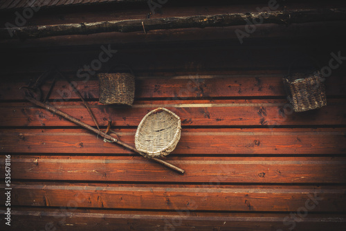 Old peasant tools hanging on wooden wall on animal farm. photo