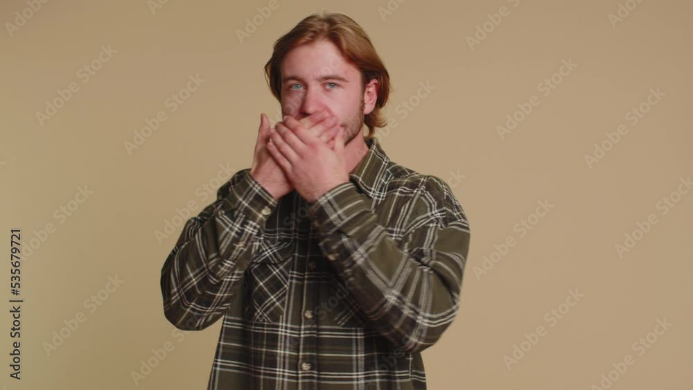 I will not say anyone. Frightened sincere man closing his mouth with hand, looking intimidated scared at camera, gestures no, refusing to tell terrible secret, unbelievable truth. Afraid young one guy I will not say anyone. Frightened sincere man closing his mouth with hand, looking intimidated scared at camera, gestures no, refusing to tell terrible secret, unbelievable truth. Afraid young one guy