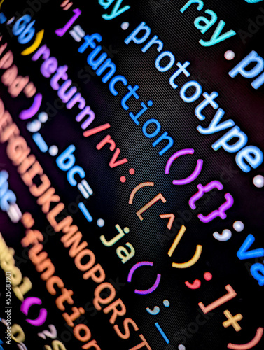 Obraz na płótnie Closeup of lines of computer code displayed on a digital screen with colorful letters and numbers in dark mode on black background w salonie