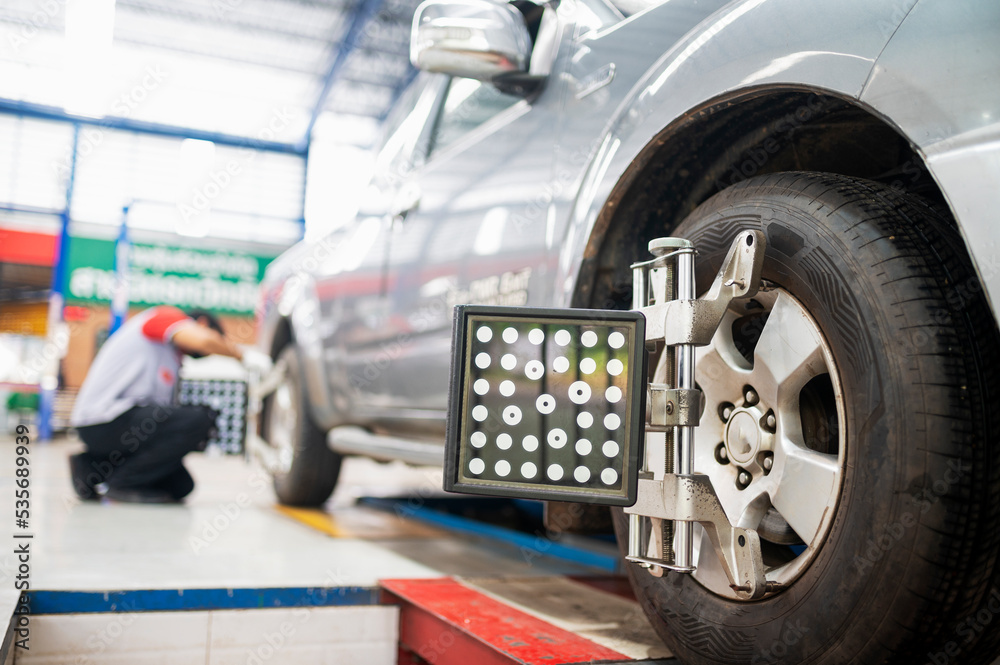 Professional mechanic near wheel center, wheel alignment, mounted on ...