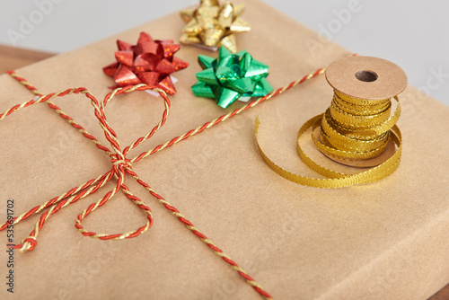 Decorative ribbons and bows on a wrapped Christmas present. Concept of preparing gifts for the holidays.