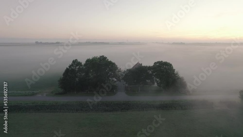 Friese boerderij op een mistige ochtend, met de koeien in de wei photo