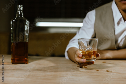 The bartender serves whiskey to customers at a bar or restaurant.