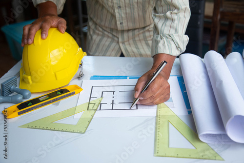 Architect designing project at Construction Site with blueprint