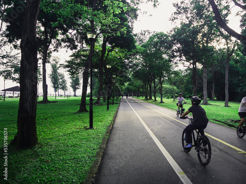 People cycling on a dedicated cycling path in East Coast Park, Singapore. Recreational activities for children and adults.