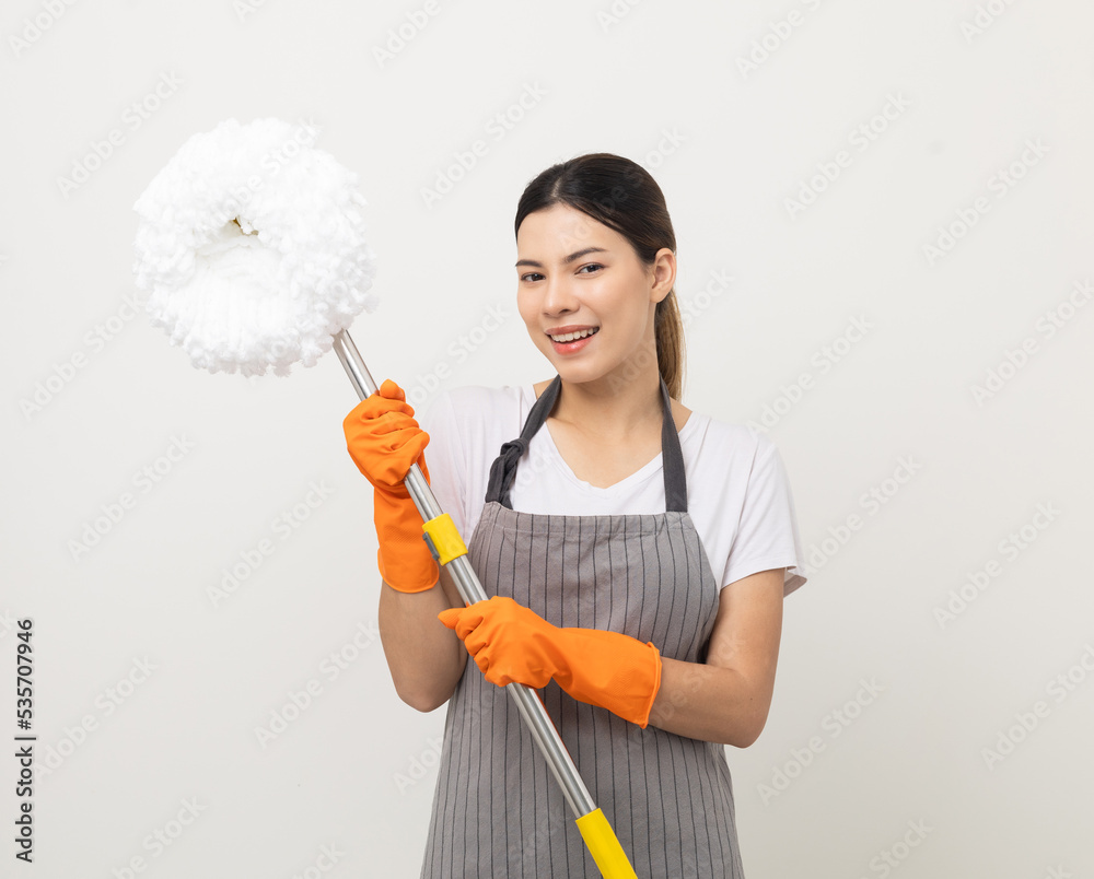Young beautiful woman with apron and rubber glove ready for cleaning home on isolated white background. Housekeeping housework or maid worker holding mop cleaning Young beautiful woman with apron and rubber glove ready for cleaning home on isolated white background. Housekeeping housework or maid worker holding mop cleaning