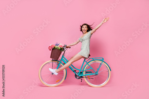 Fototapeta Naklejka Na Ścianę i Meble -  Full length photo of funny adorable girl dressed off shoulders outfit riding bike isolated pink color background
