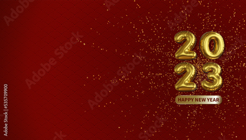 Spreading gold powder on red patterned background with golden inflatable balloons of 2023 and happy new year