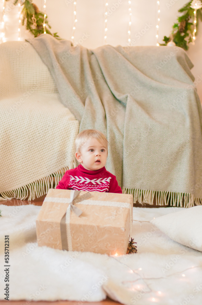 Little boy with a Christmas present in a room decorated for Christmas. Christmas mood Little boy with a Christmas present in a room decorated for Christmas. Christmas mood
