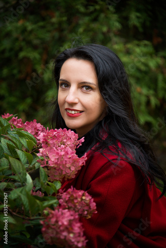 portrait of a brunette woman with red lips with rosw flowers photo