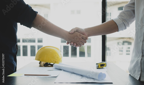Shake a hand, Team of engineers and architects, working team, meeting, discussing construction and drawing construction plans, printing, writing on-site construction sites. Home design concept