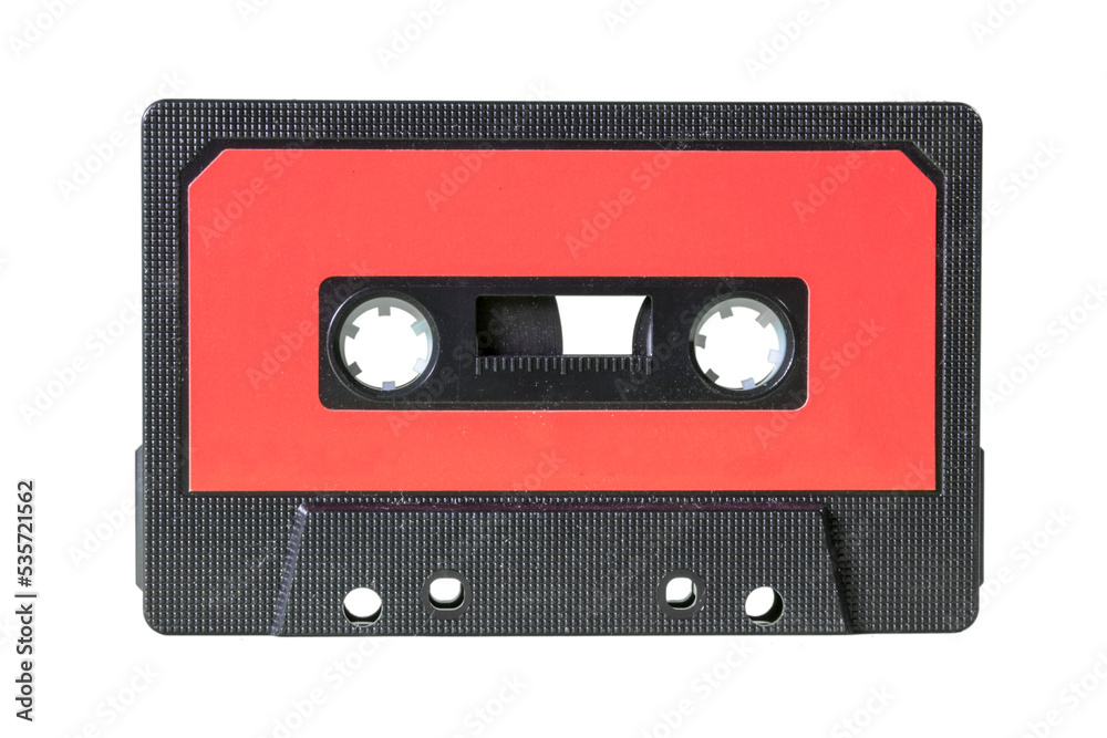 An old retro cassette tape from the 1980s (obsolete music technology). Black fine grid plastic body, red label, isolated.

