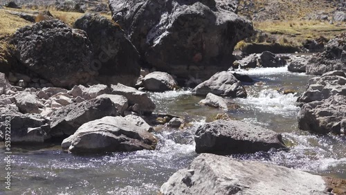 Rio pequeño cruzando camino de piedras en un sendero de Sierra Peruana 