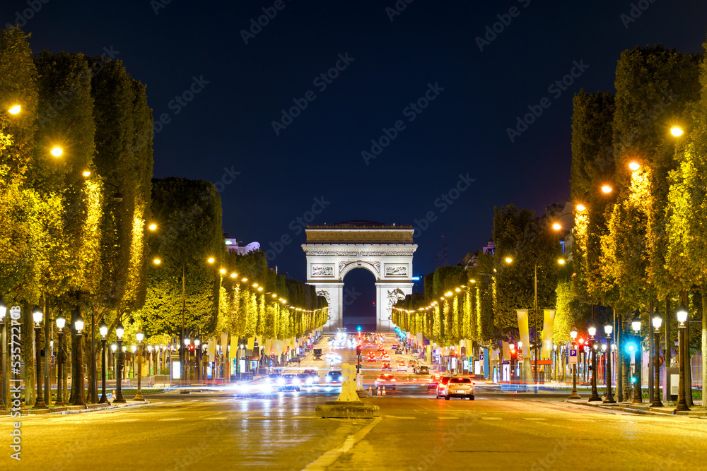 The Arc de Triomphe at night seen across des Champs-Élysées avenue in Paris, Francja - obrazy, fototapety, plakaty 