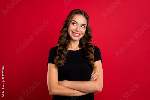 Photo of youth cheerful girl wondered look empty space dreamy folded hands isolated over red color background
