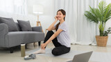 Yoga exercise concept, Young Asian woman sit to relaxing after doing yoga training online at home