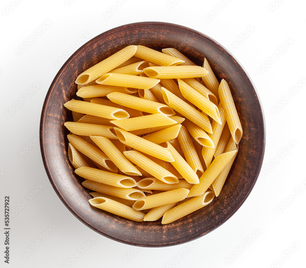 Uncooked penne pasta in ceramic bowl isolated on white background with clipping path Uncooked penne pasta in ceramic bowl isolated on white background with clipping path